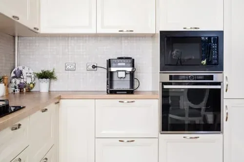 Cream kitchen with wood countertops and neatly arranged everyday essentials