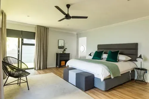 Calm, tidy bedroom with wood floors and neutral bedding