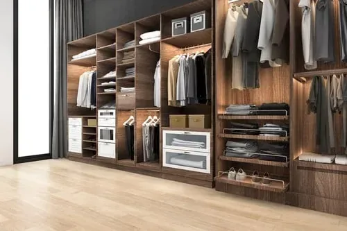 Warm walnut walk-in closet with neatly hung shirts, folded stacks and matching storage boxes